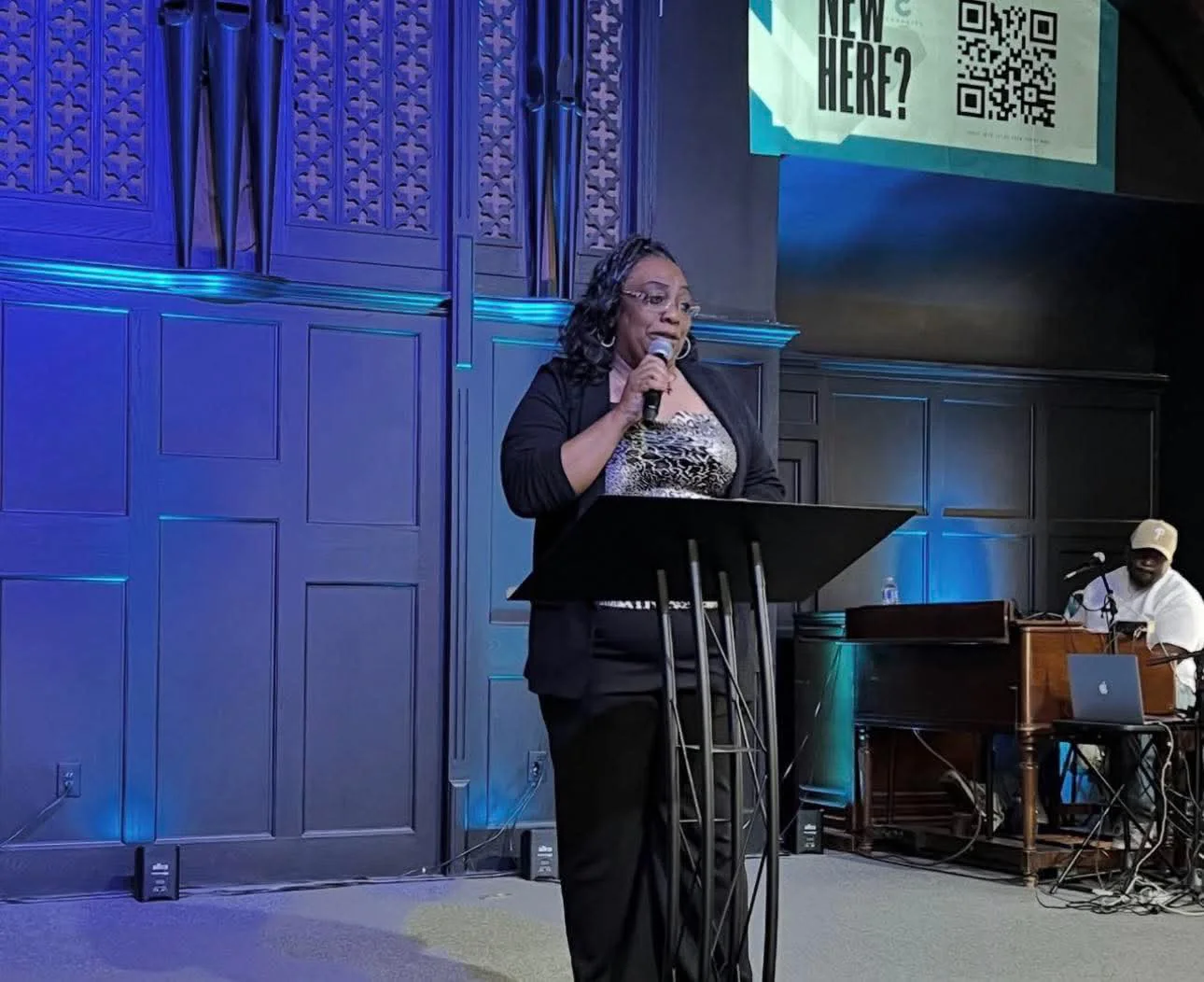 Desha Henfield speaking at a podium during a public event